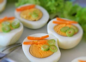 halbe Eier mit Karottenraspel und Frühlingszwiebeln