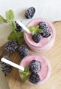 Zwei Gläser mit Smoothies und Brombeeren