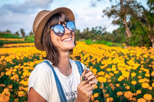 Frau mit Sonnenbrille im Blumenfeld